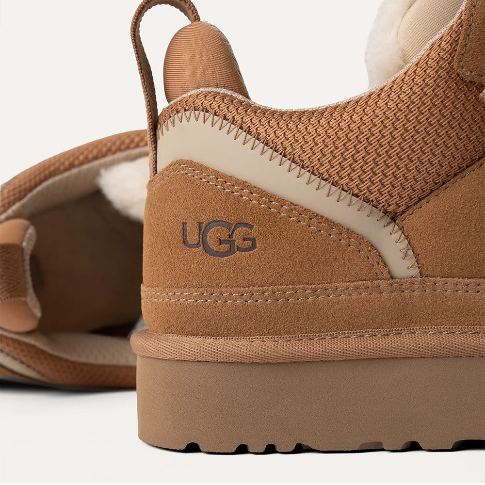 Chestnut UGG low-top sneaker, angled side view, suede, mesh, fuzzy lining, cream sole, UGG logo.