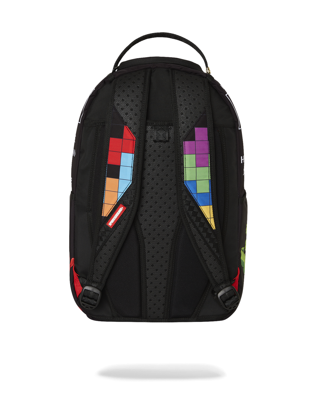 A back view of a black Sprayground backpack. The shoulder straps are padded and black, with a colorful, pixelated Tetris design on each one. The left strap has red, orange, and light blue blocks, while the right strap has green, purple, and light blue blocks. The back panel is also black and padded for comfort. A red tag with the word "SPRAYGROUND" is visible near the bottom of the left strap.
