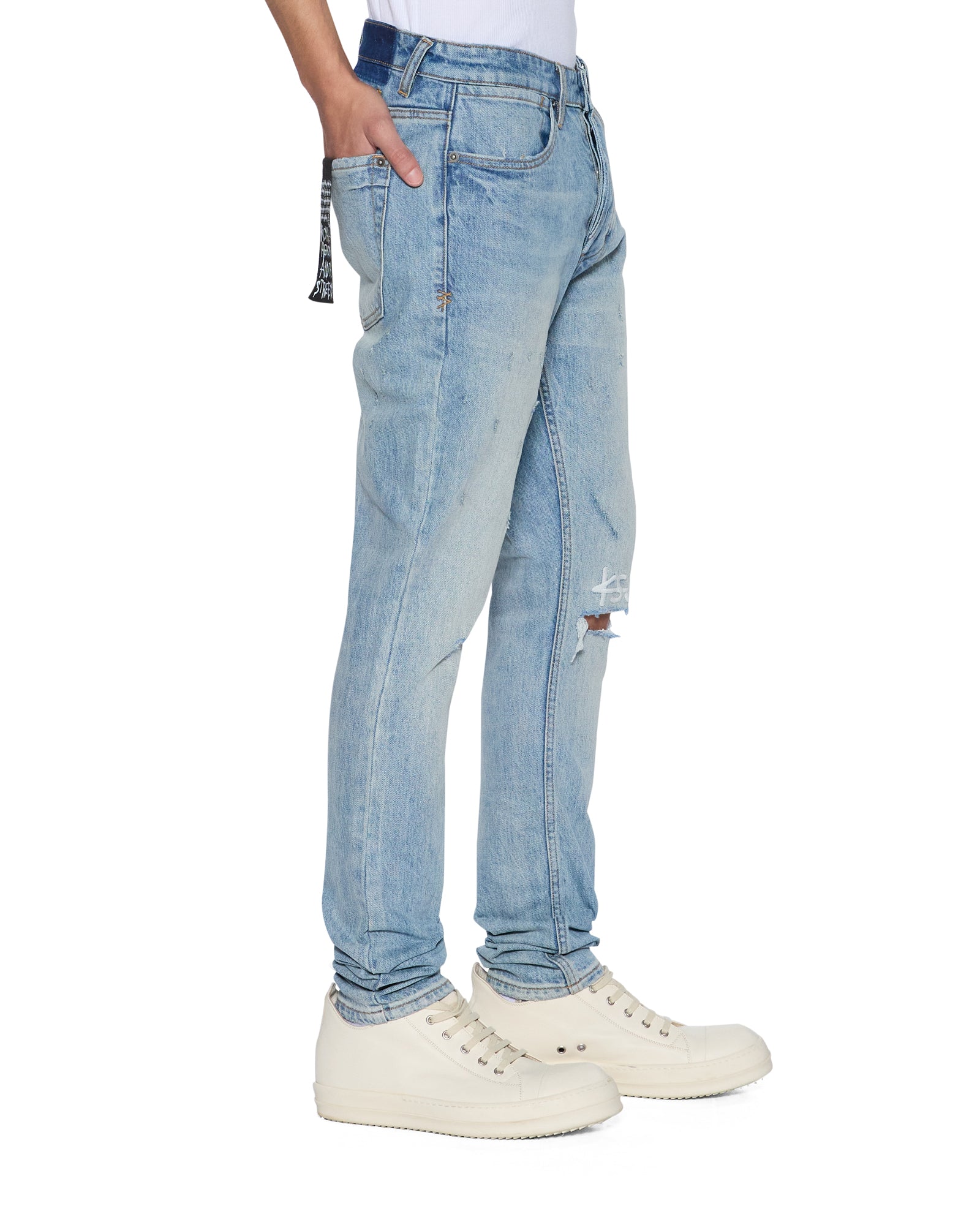side shot Light blue jeans worn by a person on a white background