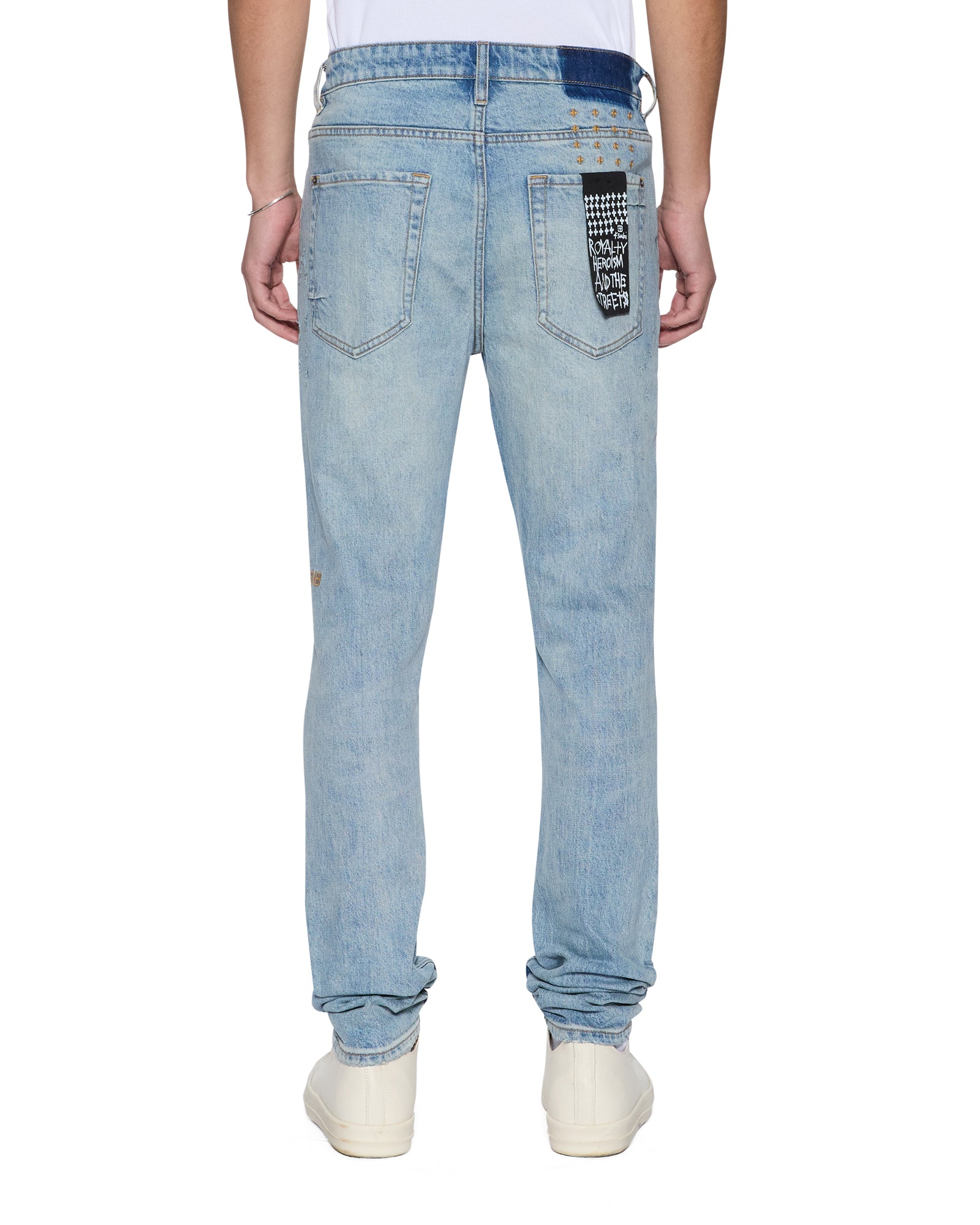 Light blue jeans with a ksubi logo on the back pocket against a white background