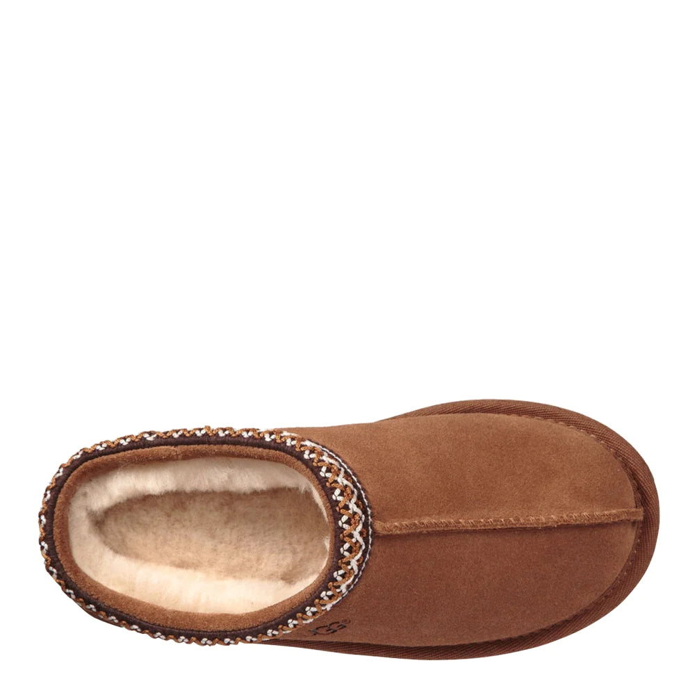 Top-down view of a single UGG Kids Tasman slipper in chestnut. The image shows the suede footbed and the plush, white wool interior lining, framed by the braided Tasman stitch detailing around the opening.