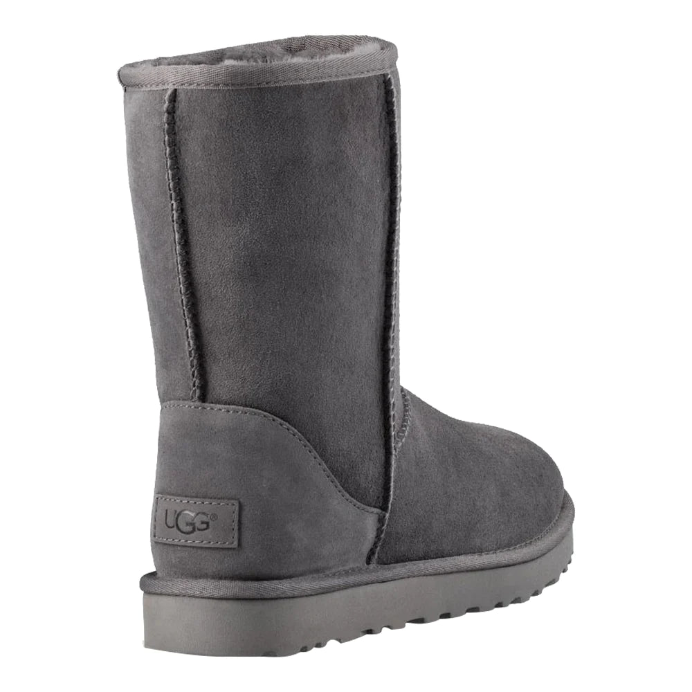 Rear view of UGG Women's Classic Short II boot in dark grey suede. The image focuses on the back of the boot, showing the vertical back seam, the suede heel patch with the tonal UGG logo, and the height of the mid-calf shaft.