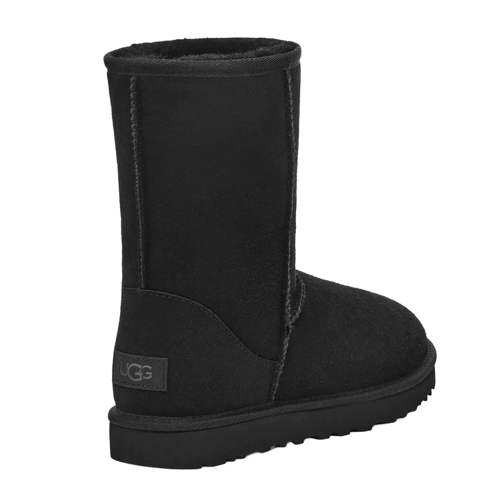 Rear Angled view of a single black UGG Women’s Classic Short II boot, displaying the UGG logo patch on the heel and the texture of the suede.