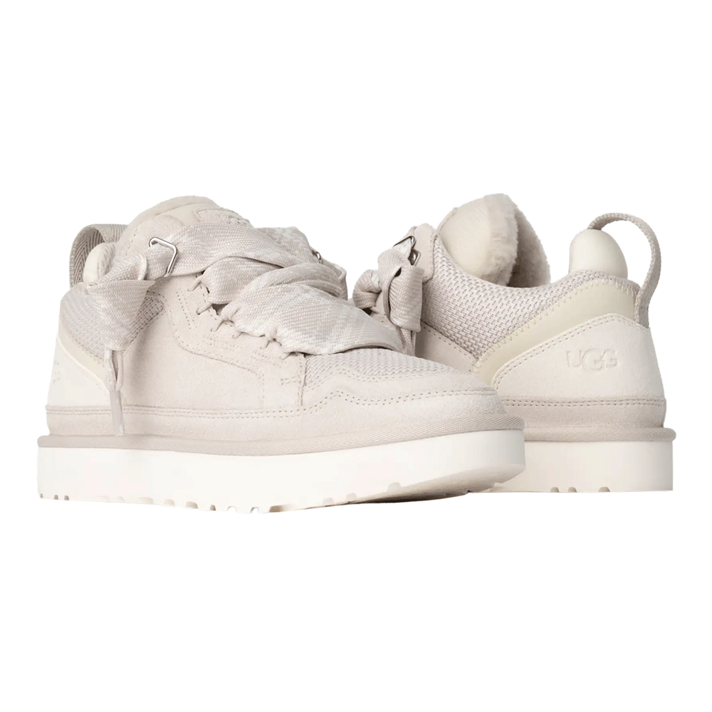 A pair of UGG Lowmel sneakers in a light color, seen from the back and side, emphasizing the UGG logo embossed on the heel, the pull tab, and the plush wool lining visible around the padded collar.
