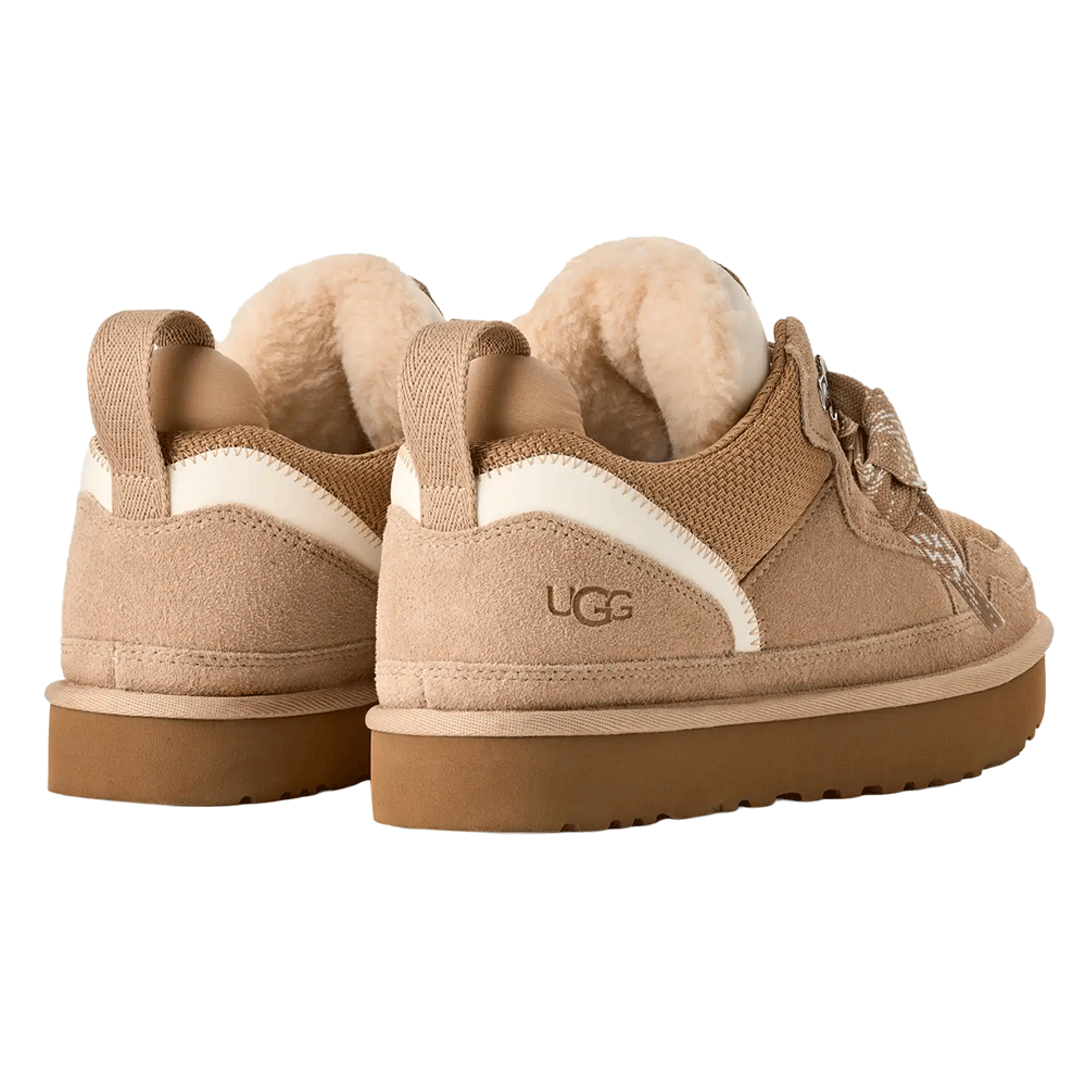 Rear-angle view of a pair of UGG Lowmel sneakers in tan, emphasizing the plush, exposed UGGplush wool lining, the embossed UGG logo on the suede heel, and the webbing heel strap.