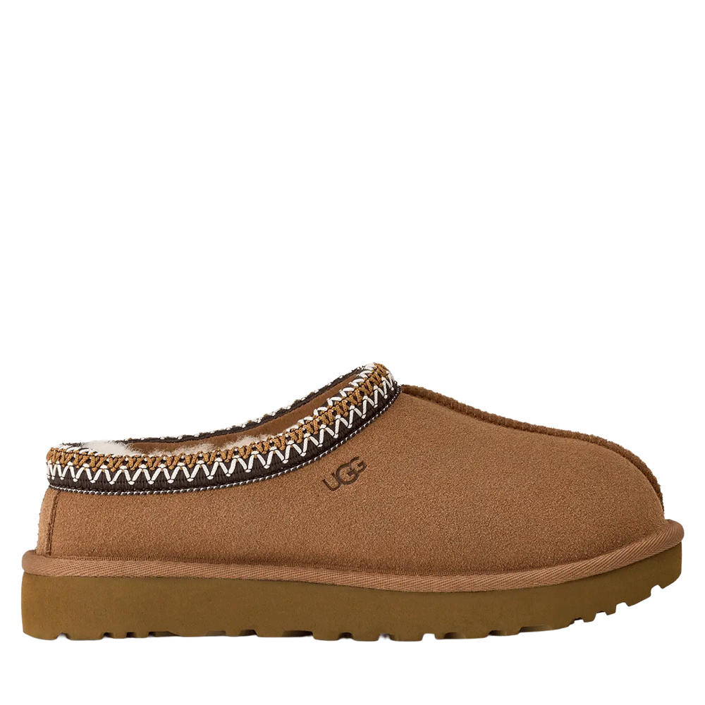 UGG Tasman II slipper in a chestnut brown suede, shown in profile. The slipper features a low slide-in profile, a thick, brown sugarcane EVA sole, and the signature UGGbraid detail around the collar in white and darker brown patterns. The UGG logo is embossed on the side.