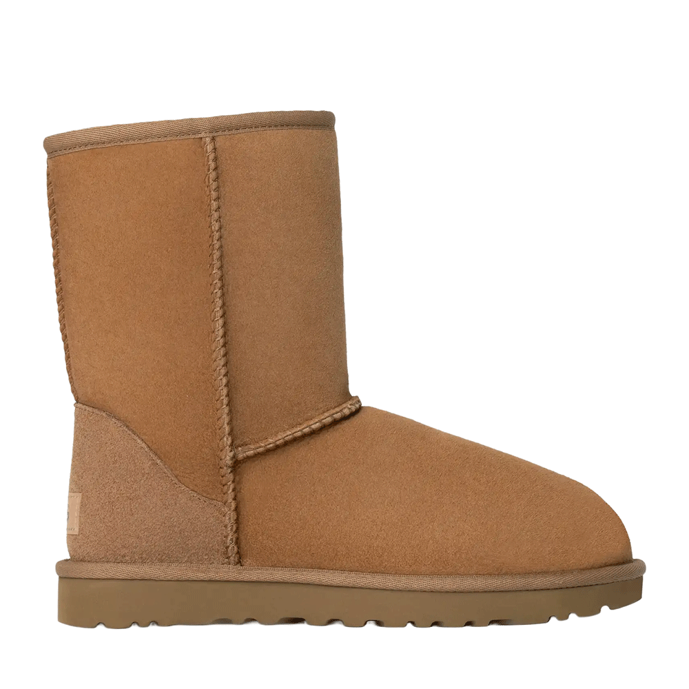 A side view of a single UGG Women's Classic Short II boot in the light brown chestnut color. The boot features a mid-calf shaft, visible overlock stitching along the seams, and a ridged brown Tredlite outsole.