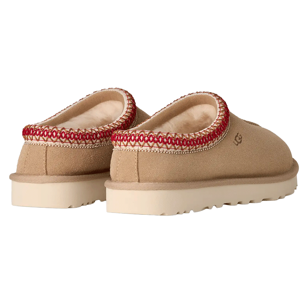 Back view of Sand UGG Tasman II slippers, highlighting the red and white UGGbraid trim and the plush sheepskin interior.