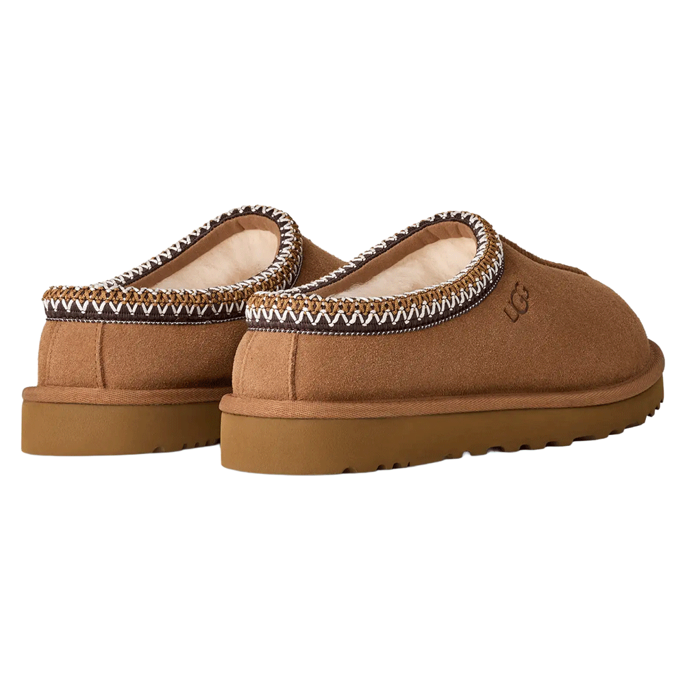Top/Back view of the chestnut UGG Tasman II slipper. The image shows the plush, cream-colored sheepskin lining and insole, the internal UGG logo tag, and the multi-colored UGGbraid trim around the collar. The suede upper has a central seam extending to the rounded toe.