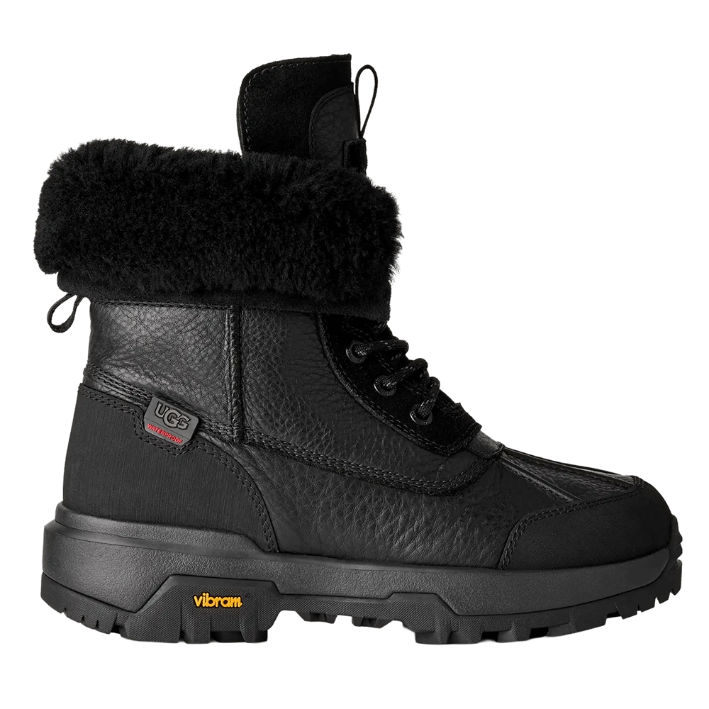 Side view of the Black UGG Adirondack Boot XXV, featuring a waterproof genuine leather upper, plush black fur cuff, lace-up front, and a durable black Vibram ICETREK outsole for extreme winter conditions.