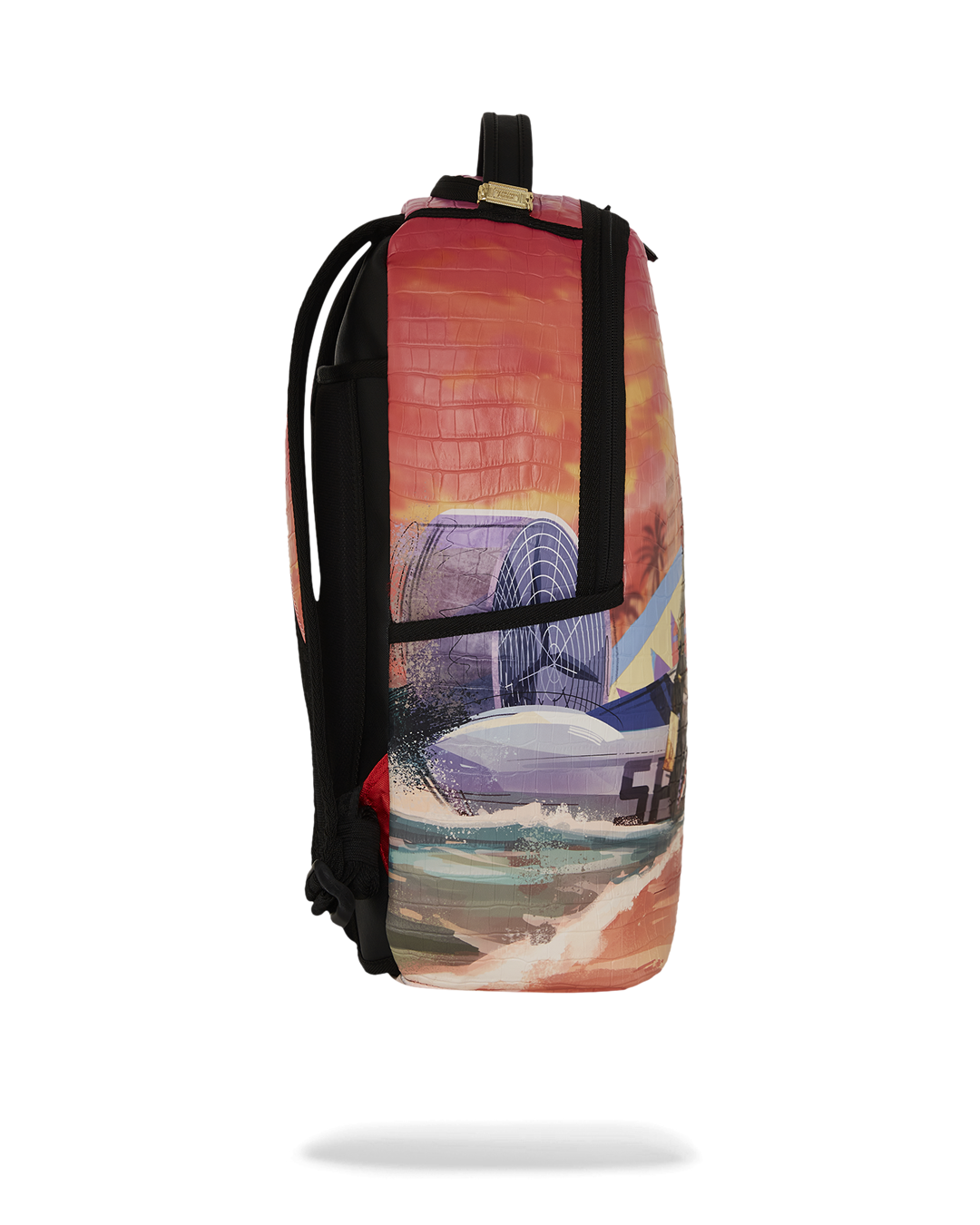 A side view of a colorful Sprayground backpack with a graphic of an alligator on a beach at sunset. The graphic on this side shows crashing waves, a surf van with a shark mouth design, and a palm tree silhouetted against an orange and pink sky. The backpack has a subtle crocodile-skin texture. The side pockets are black and the main zipper is also black.

