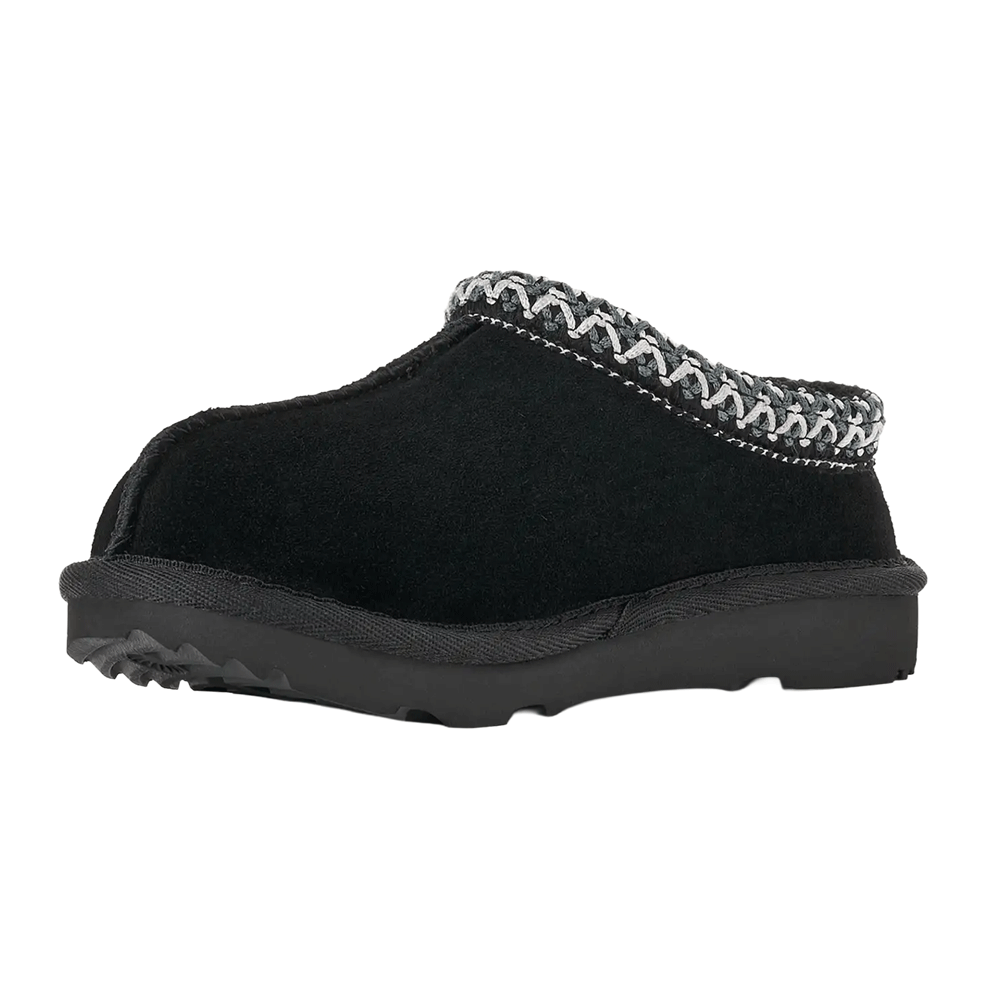 Front Angled view of the black Kids' UGG Tasman slipper/shoe, highlighting the thick black sole with visible tread near the toe and the grey and white UGGbraid detail wrapping around the collar.