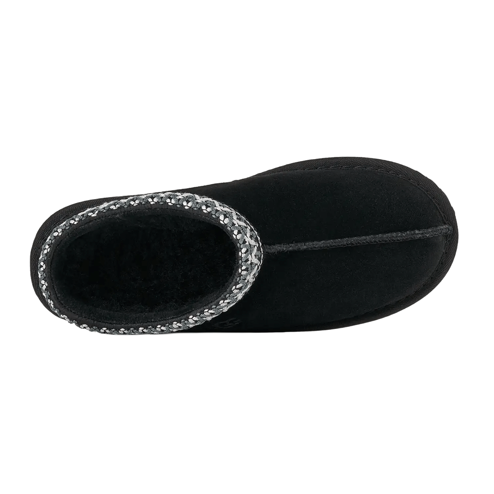 Top-down view of the black Kids' UGG Tasman slipper, showing the plush black UGGplush lining , the grey and white UGGbraid trim, and the suede stitching running down the center of the toe.