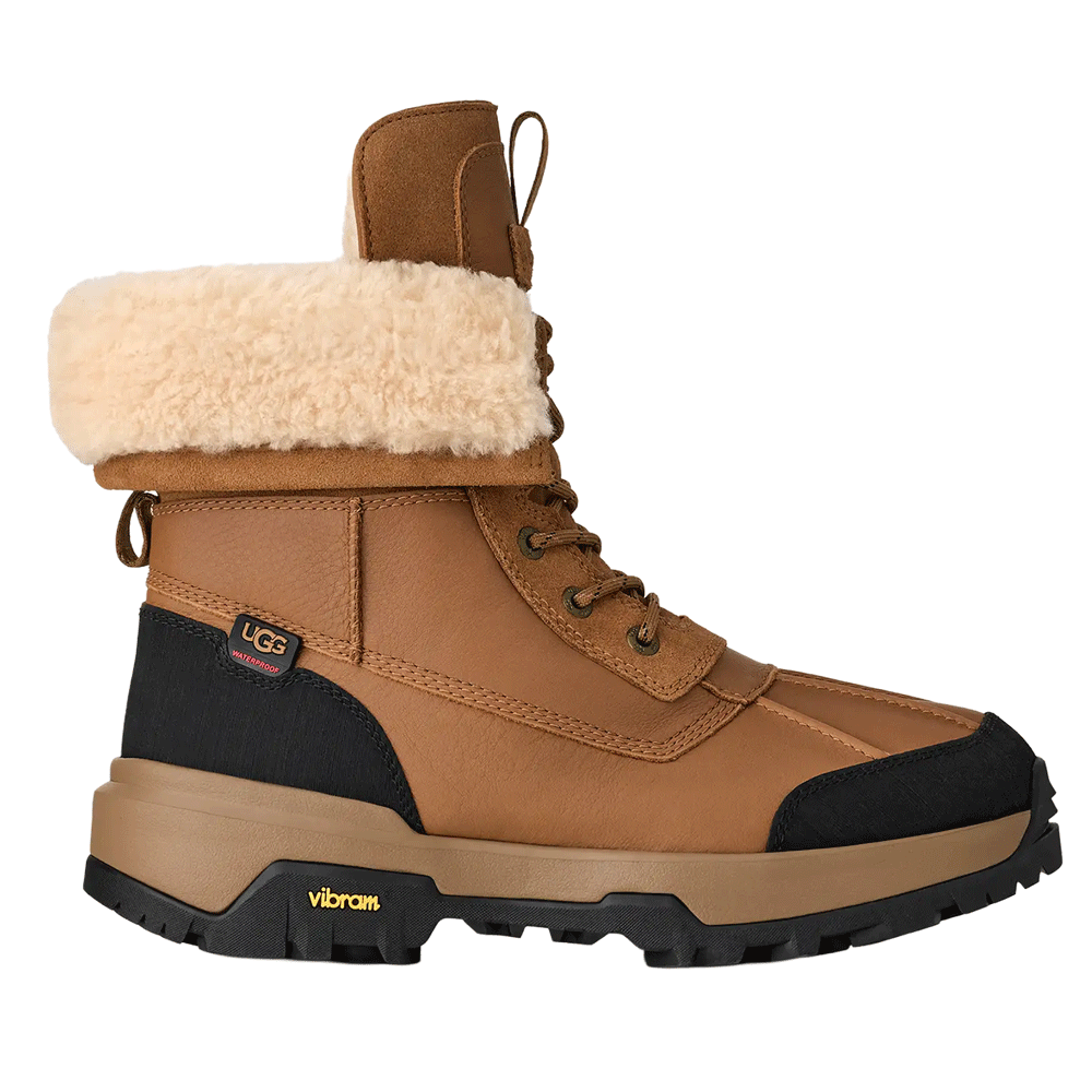Chestnut brown waterproof UGG leather boot with a cream shearling cuff, black accents, and a heavy-duty Vibram sole.