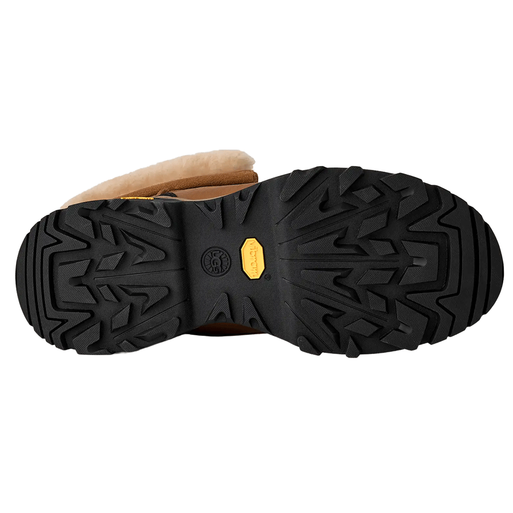Bottom view of the UGG boot, showcasing the black Vibram rubber outsole with aggressive treads for winter traction.