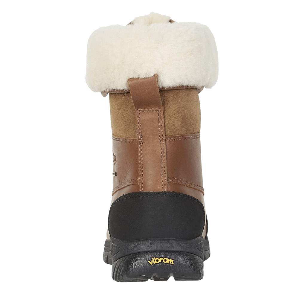 Straight rear view of a single UGG® Men’s Butte Boot in Worchester. The image highlights the fluffy sheepskin cuff, the brown leather heel, and the black outsole which features the visible yellow Vibram logo for high-performance traction.