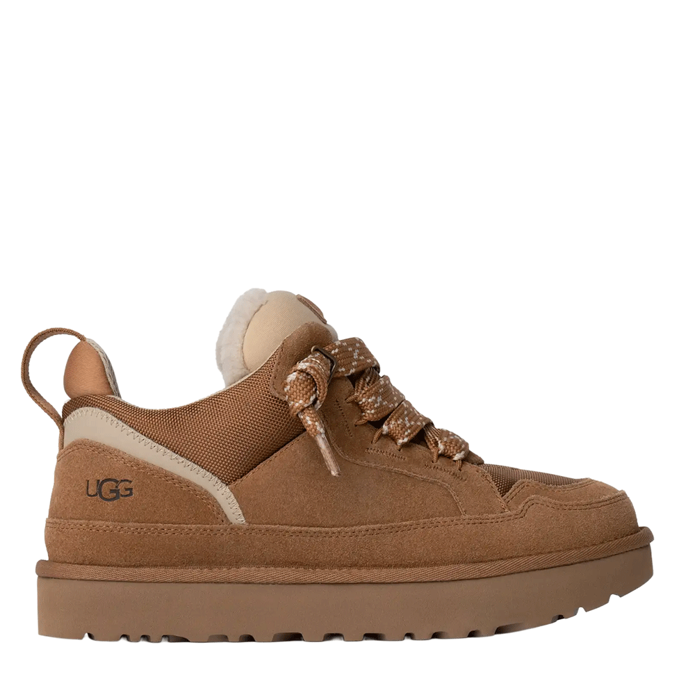 Side view of a low-top UGG shoe in chestnut suede and textile, featuring thick speckled laces, a cream-colored plush lining visible at the collar, and a substantial brown platform sole with a lugged tread.