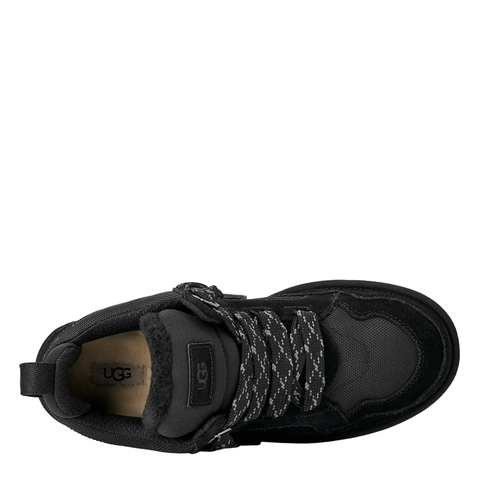 Top-down view of the black UGG low-top shoe, clearly showing the plush black lining, the black suede and mesh upper, the speckled black and white laces, and the UGG logo stamped on the light brown insole.