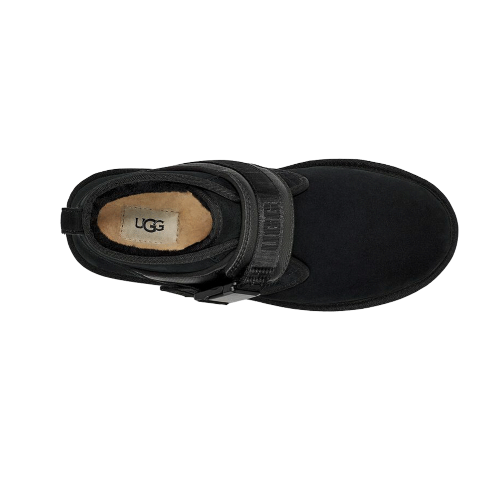 Top-down view of the black UGG Men's Neumel Snapback boot, showing the suede toe box, the wide black strap with the snap buckle closure, and the cozy, visible interior lining with the UGG logo label on the insole.