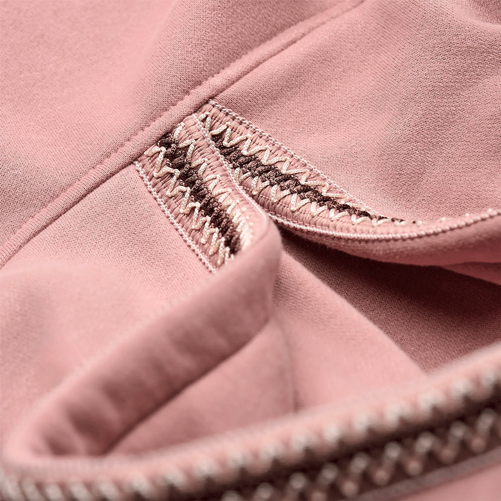 Close-up of the multi-colored braided zig-zag trim detail on the dusty rose UGG hoodie.