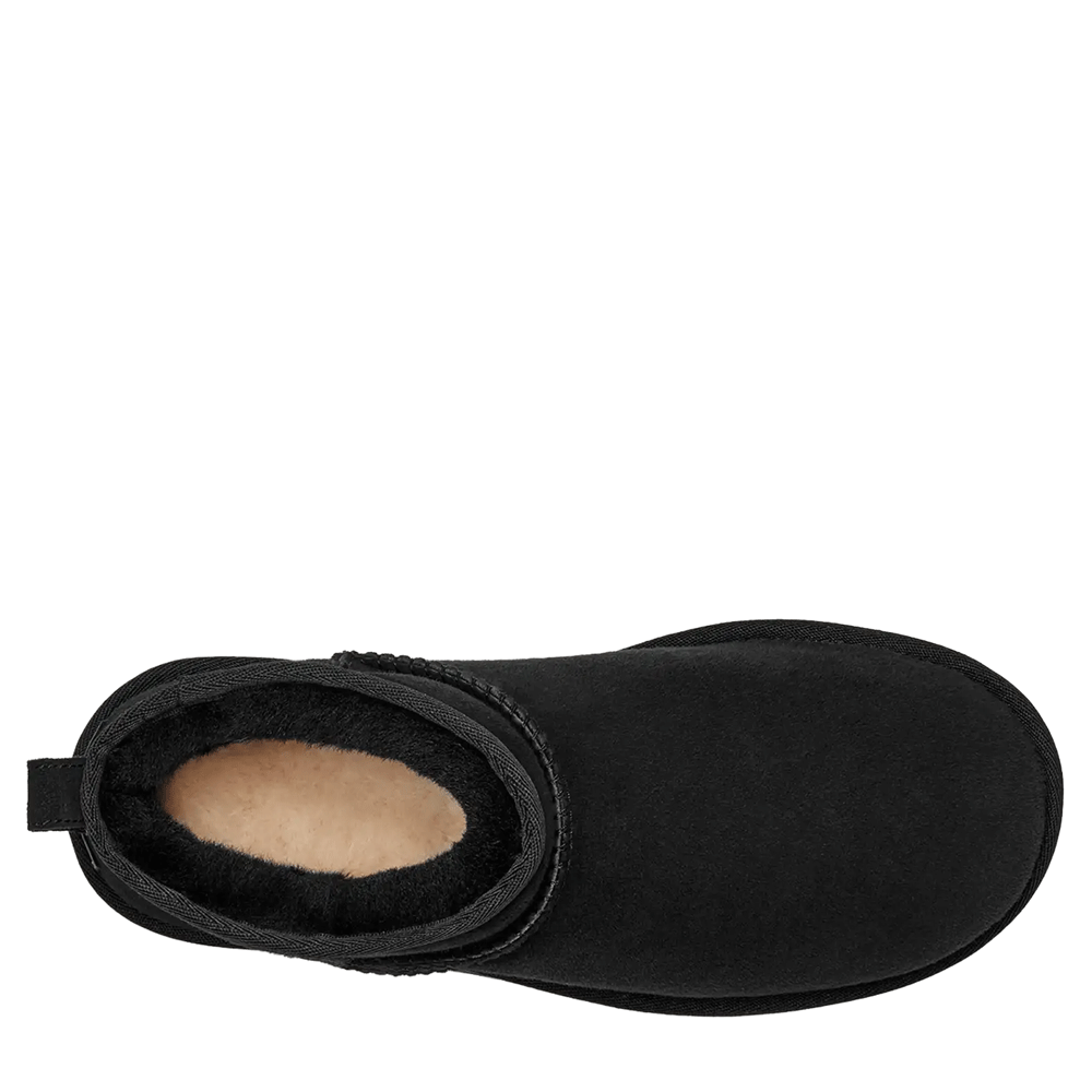 Top-down view of a single UGG Women's Classic Ultra Mini boot in black. The view looks directly down into the short shaft, showcasing the creamy sheepskin wool lining and the wide, rounded toe box.