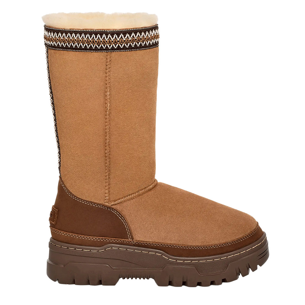 Side view of the Classic Tall TrailGazer UGG boot with a waterproof suede and Twinface Sheepskin shaft, featuring the signature UGGbraid woven detail at the cuff. The boot has a durable brown leather mudguard and heel, a thick platform sole, and a white plush UGGplush interior lining.