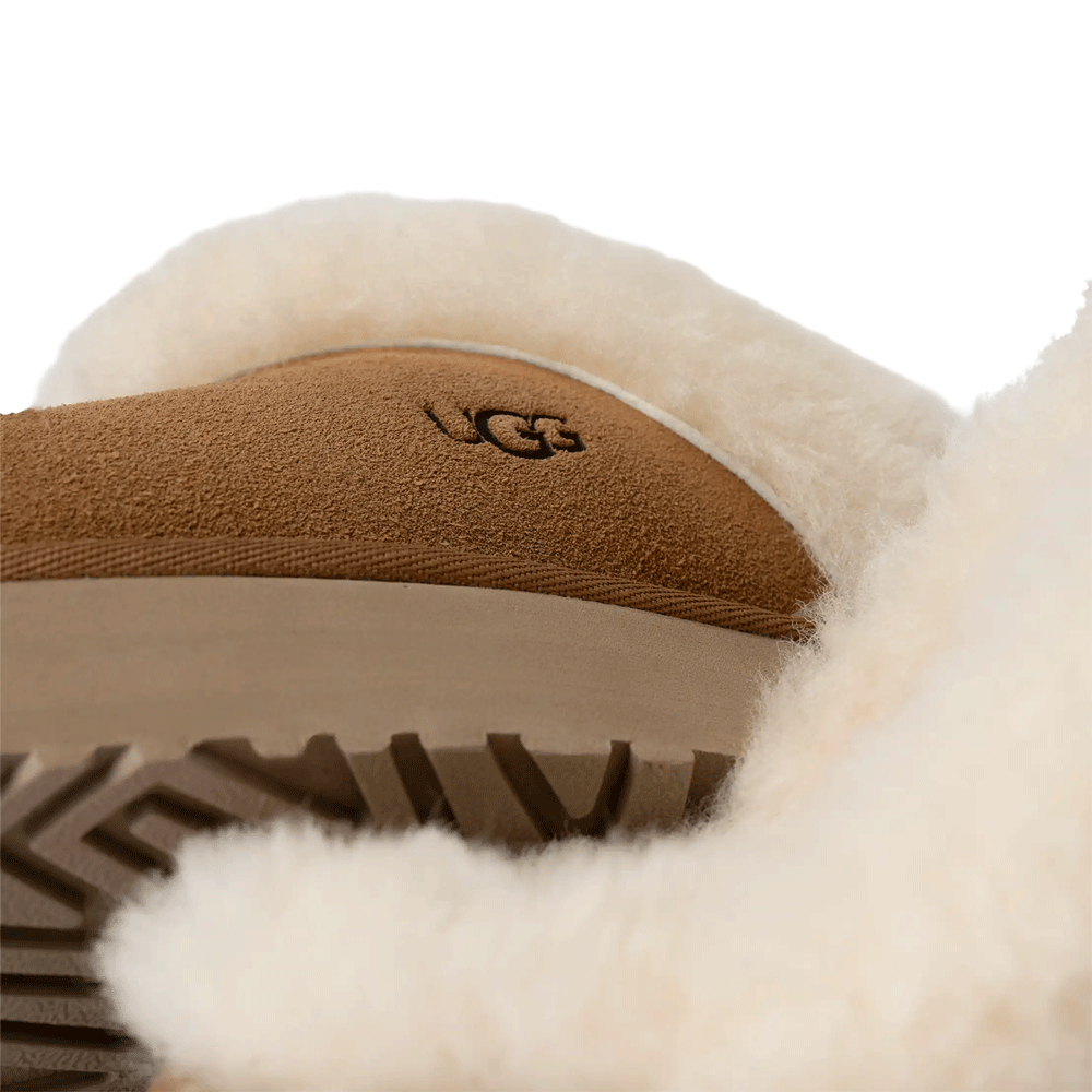 Extreme Close-up detail of the UGG Disquette showing the heat-embossed UGG logo, the suede texture, and the rugged tread of the platform sole
