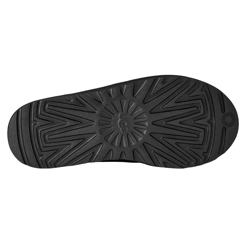Bottom view of the black Sugarcane EVA outsole of the UGG Tasman II slipper, showing the non-slip, zig-zag traction pattern and the circular UGG logo tread detail in the center.