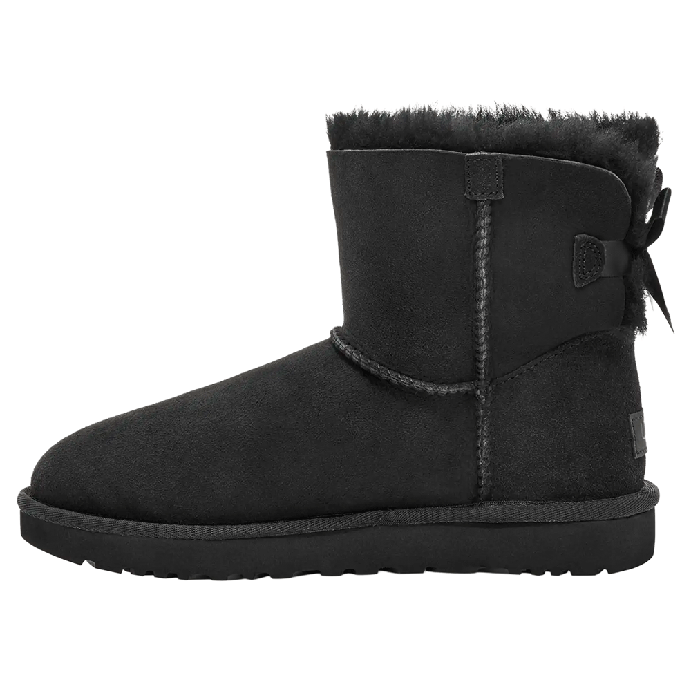 Side view of the Black UGG Mini Bailey Bow II boot, featuring a short black Twinface sheepskin shaft, a plush black fur cuff, a subtle black bow at the back, and a durable black Sugarcane EVA or Treadlite outsole.