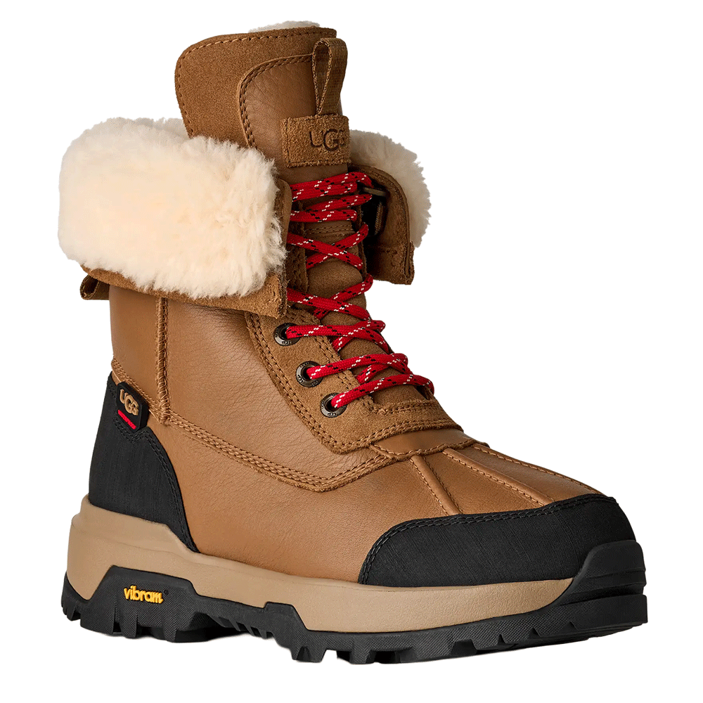 Front perspective view of the Chestnut UGG Adirondack Boot XXV, showcasing the waterproof leather upper, cream-colored fur cuff, the red speckled laces, and the rugged Vibram outsole.