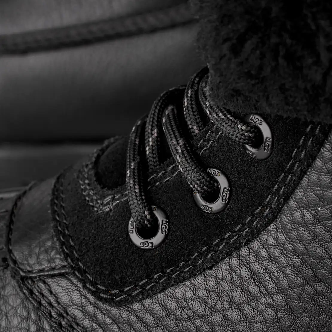 Close-up of black leather shoes with laces and stitching details.