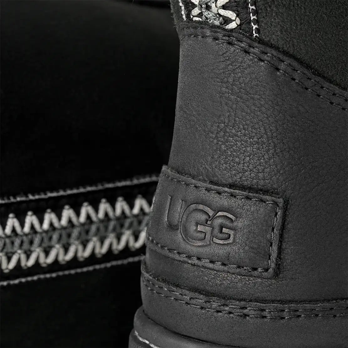 Close-up of a black UGG boot with brand logo on a blurred background