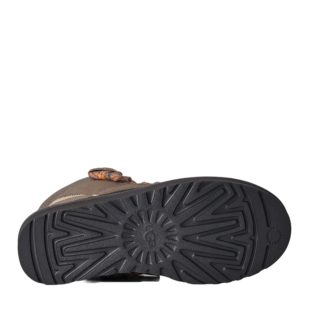Bottom view of the Cobble Grey UGG Highmel sneaker sole, showcasing the dark gray Sugarcane EVA outsole with the classic UGG sunburst tread pattern.
