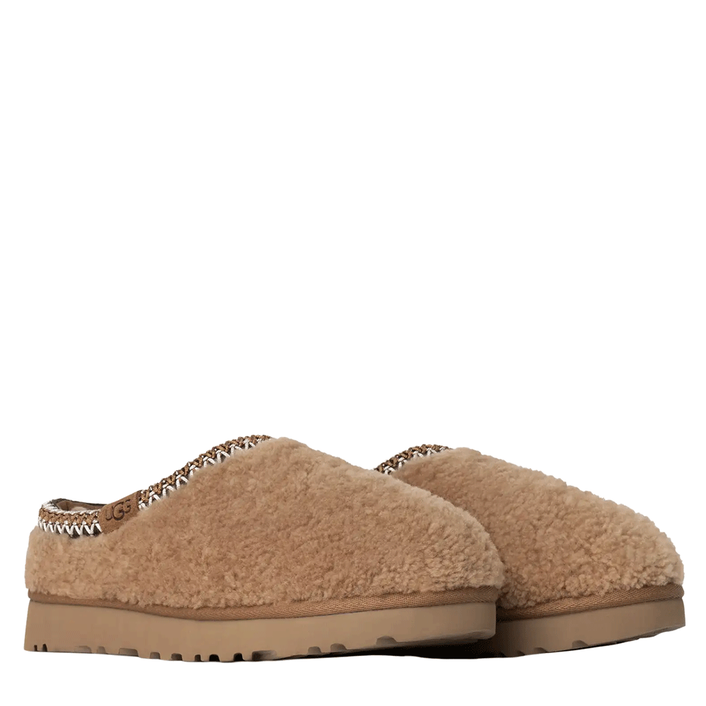 A pair of Chestnut suede UGG low-top shoes, one standing upright showcasing the upper and the other lying on its side to display the bottom of the lugged sole.