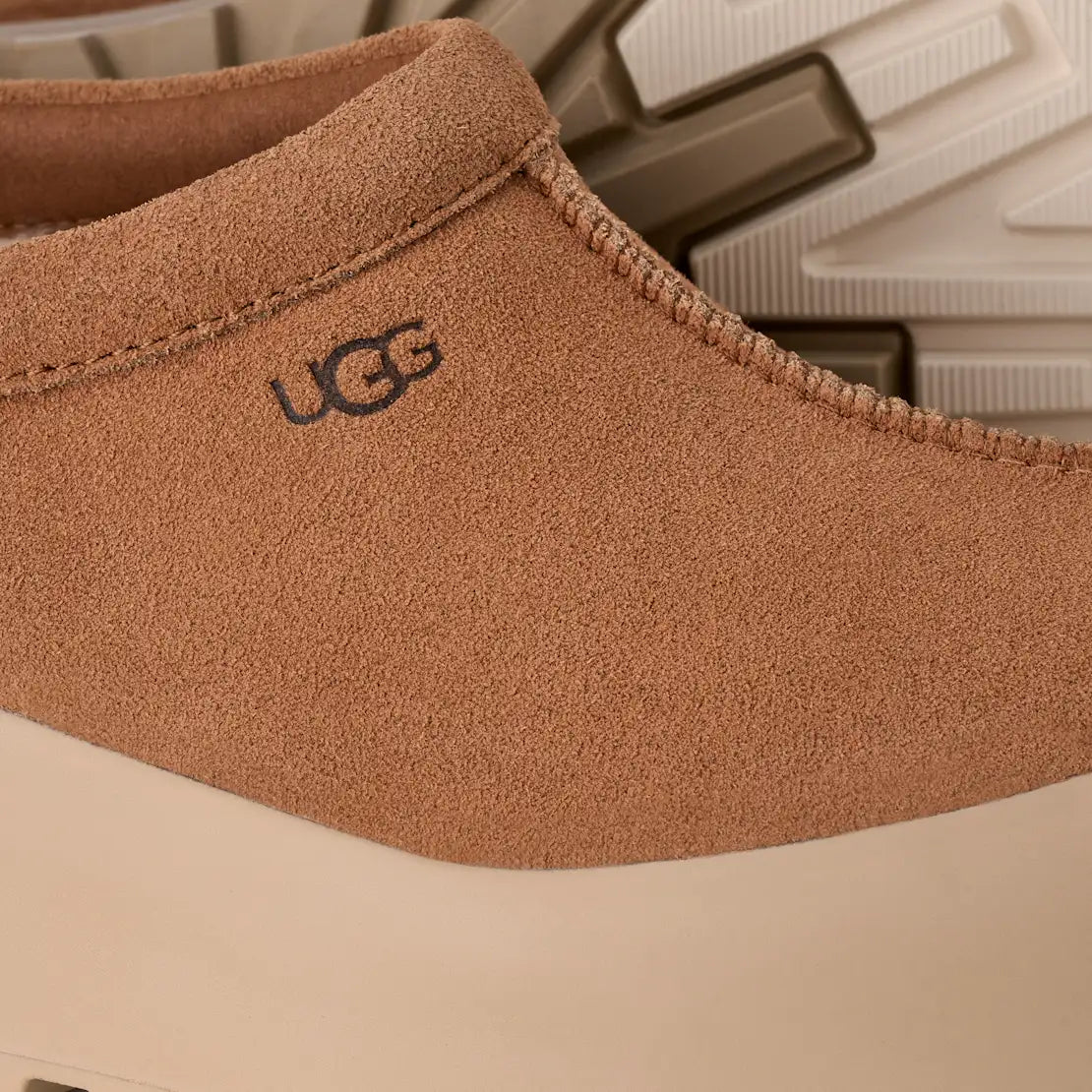 Close-up of a brown UGG slipper with the brand logo.